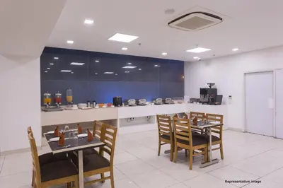 a dining room with two tables and chairs and a counter at Ginger Mysore in Mysore