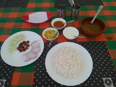 a table with two plates of rice and other ingredients at Kannur west beach homestay in Kannur