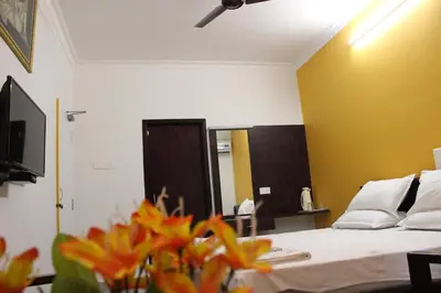 a hotel room with a bed and a mirror at Sri Aarvee Hotels in Coimbatore