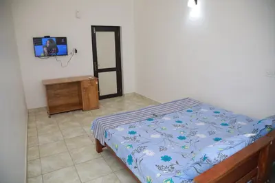 a bedroom with a bed and a tv on a wall at Thekkumpuram Tourist Home in Malappuram