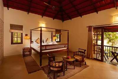 a bedroom with a bed and a table and chairs at Raindrops Resorts Wayanad in Sultan Bathery