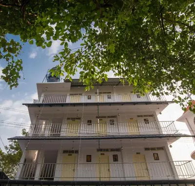 a tall white building with balconies at Gems 9 Airport Hotel in Nedumbassery
