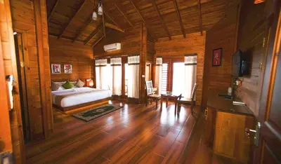 a bedroom with a bed in a wooden room at LakeRose Wayanad Resort in Ambalavayal