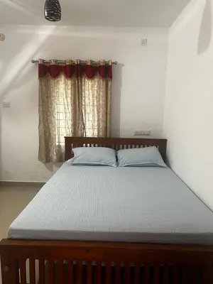a bed in a bedroom with a window at Takashi Homestay North Paravur Near Muziris in North Paravur
