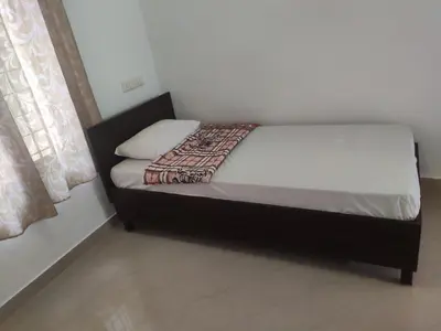 a small bed in a room with at Takashi Homestay North Paravur Near Muziris in North Paravur