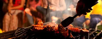 a person cooking food on a grill with a spatula at Mount n Mist in Ooty
