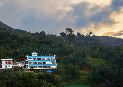 a large building on top of a hill at Mount n Mist in Ooty