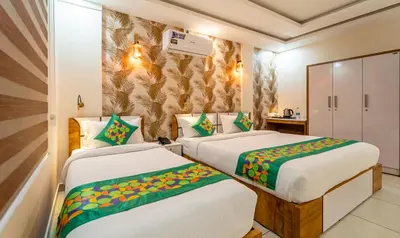 two beds in a hotel room with avertisement for at Treebo Thoduvas Star Plaza Cochin Airport in Nedumbassery