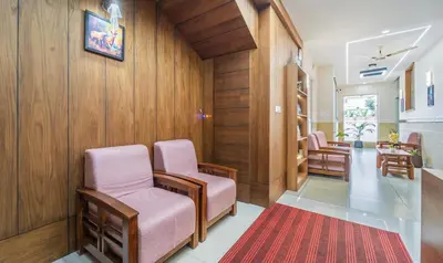 a waiting room with pink chairs and a red rug at Treebo Thoduvas Star Plaza Cochin Airport in Nedumbassery