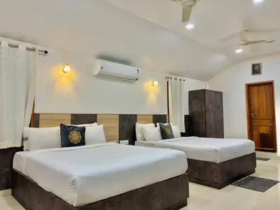 two beds in a hotel room with two beds at Riyavar Luxury Stay in Siddapur