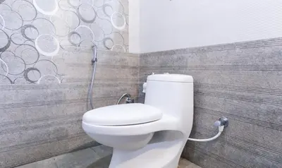 a white toilet in a bathroom with a shower at Treebo Sandpipers Kushalnagar in Kushālnagar