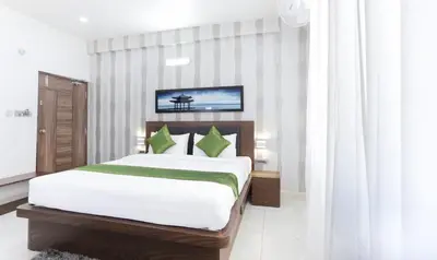 a bedroom with a large bed in a room at Treebo Sandpipers Kushalnagar in Kushālnagar