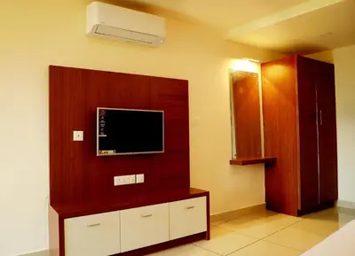a living room with a flat screen tv on a wall at Wayanad Royal Crown in Kalpetta