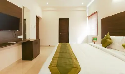 a bedroom with a large bed with a flat screen tv at Treebo Hi Line Apartments Kalapatti in Coimbatore