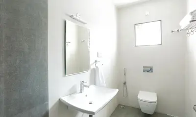 a white bathroom with a sink and a toilet at Treebo Hi Line Apartments Kalapatti in Coimbatore