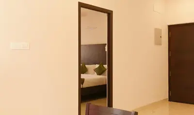 a mirror in front of a bedroom with a bed at Treebo Hi Line Apartments Kalapatti in Coimbatore