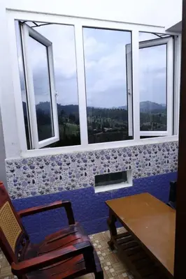 a room with a table and chairs and windows at Sri Nandha Luxury Comforts in Vālpārai