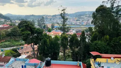 a view of a city with buildings and trees at smile stone individual cottage in Ooty