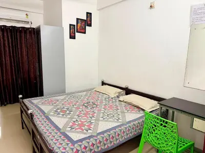 a bedroom with a bed with a quilt on it at Siva Inn in Guruvāyūr