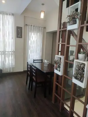 a dining room with a table and a book shelf at Snowdrops Ooty in Ooty