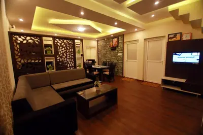 a living room with a couch and a tv at Snowdrops Ooty in Ooty
