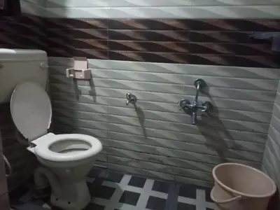 a bathroom with a toilet in a stall at Hill Inn Rooms an HomeStay in Ooty