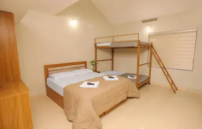 a bedroom with a bed and a bunk bed at Nandanam Villa in Kaniyāmbetta