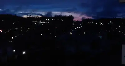 a view of a city at night at Aanvis inn in Ooty