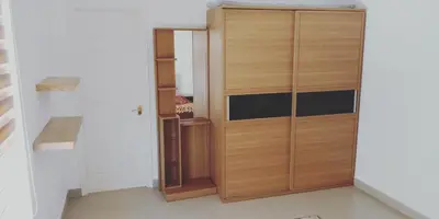a closet with a wooden door in a room at Aanvis inn in Ooty