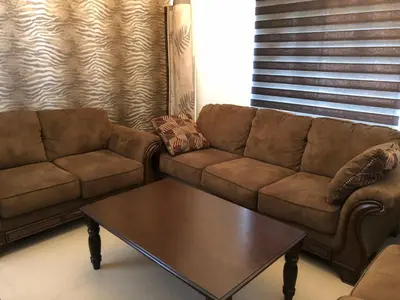 a living room with a couch and a coffee table at Aanvis inn in Ooty