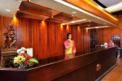 a woman is standing in a wood paneled lobby at Trichur Towers in Trichūr