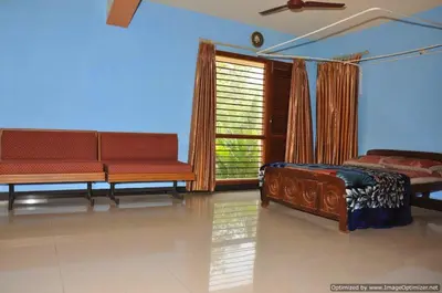 a bedroom with two beds and a large window at Suvarna Luxury Home Stay in Mysore