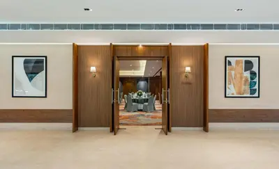 a room with doors with a table in the background at Southern Star,Mysore in Mysore