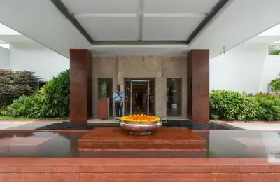 a woman standing in a building with a bowl of flowers at Southern Star,Mysore in Mysore
