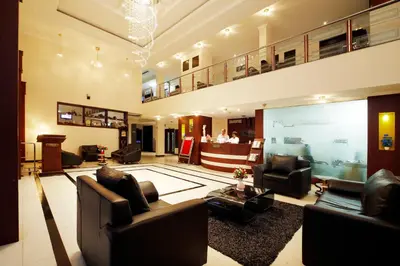 a large living room with couches and a large screen at Rose International Hotel in Nilambūr