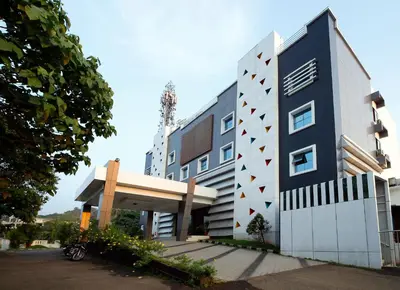 a building with a blue and white building at Rose International Hotel in Nilambūr