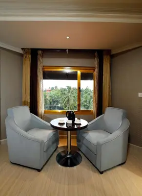 two chairs and a table in a room with a window at Hotel Park Residency in Nilambūr