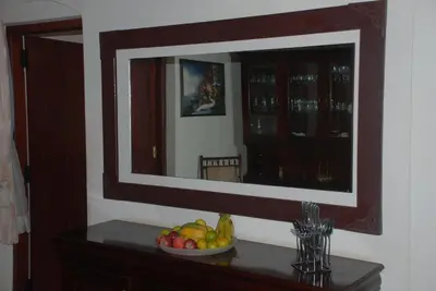 a mirror on a wall with a bowl of fruit on a table at Colonial 4 B/R Home, Great for Families, Coonoor in Coonoor