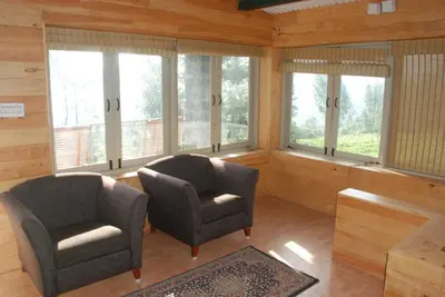 two chairs sitting in a room with windows at Relaxing 2 B/R Estate House, Deenaty, Tamil Nadu in Coimbatore