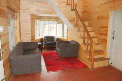 a living room with two chairs and a staircase at Relaxing 2 B/R Estate House, Deenaty, Tamil Nadu in Coimbatore