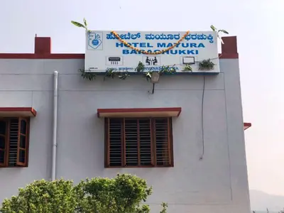 a building with a sign on the side of it at KSTDC Hotel Mayura Bharachukki, Shivanasamudra in Sivasamudram