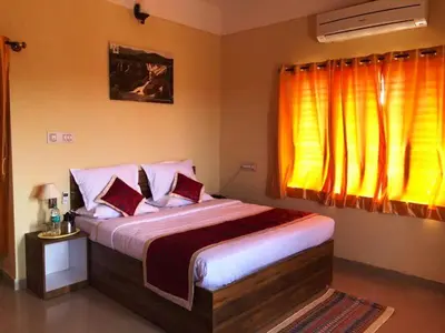 a bedroom with a large bed and a window at KSTDC Hotel Mayura Bharachukki, Shivanasamudra in Sivasamudram