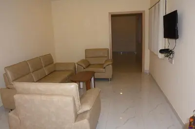 a living room with two couches and a television at KSTDC Hotel Mayura Bharachukki, Shivanasamudra in Sivasamudram