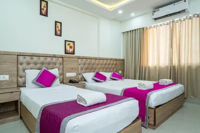 two beds in a hotel room with pink pillows at Nexstay Crystal Residency in Kozhikode