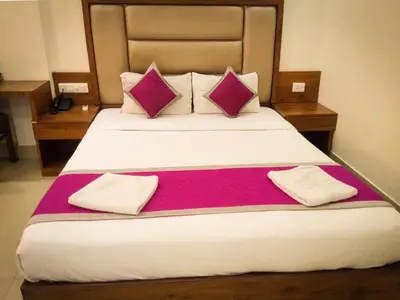 a bedroom with a large bed with purple and white pillows at Nexstay Crystal Residency in Kozhikode