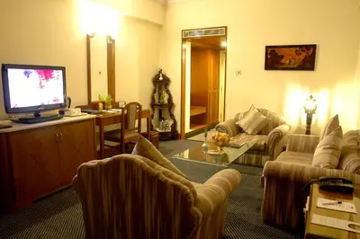 a living room with a couch and a television at Sandesh The Prince in Mysore