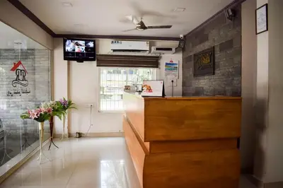 a restaurant with a counter and a television in a room at Ruby Residency in Kozhikode