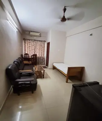 a living room with a couch and a bed at Ruby Residency in Kozhikode