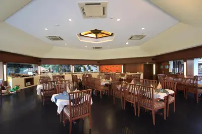 a dining room with tables and chairs in a restaurant at Silent Shores Resort & Spa in Mysore