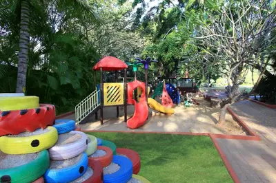 a playground with a stack of colorful tires in a park at Silent Shores Resort & Spa in Mysore